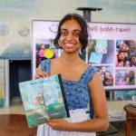 pratya poosala holding a chidlren's book